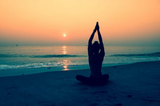 silhouette-woman-doing-yoga-beach